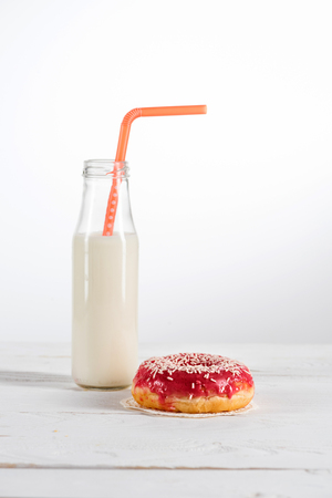sweet doughnut and fresh milk in glass bottleの写真素材