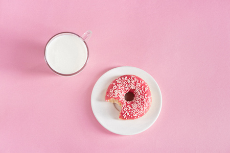 top view of glass cup of milk with donut on plateの写真素材