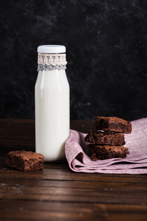 milk in glass bottle and homemade brownie cakesの写真素材