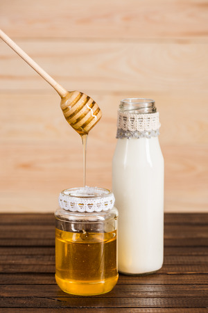glass bottle of milk with honey in jarの写真素材