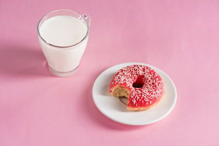 top view of glass cup of milk with donut on plateの写真素材
