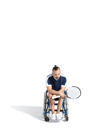 young man sitting in wheelchair and holding tennis racquetの写真素材