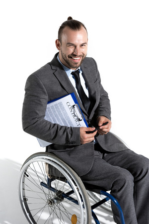 physically handicapped businessman in wheelchair holding clipboard with contractの写真素材