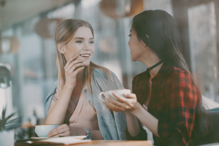 attractive multicultural women on coffee break in cafeの写真素材