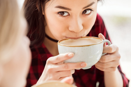 woman drinking coffee from big cupの写真素材