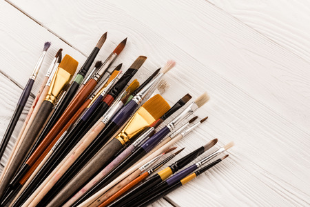 various paintbrushes collection on wooden table