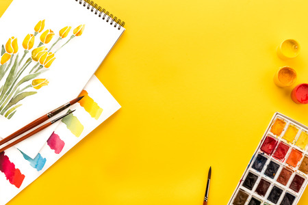 drawings of flowers, paints and brushes on yellow, springtime conceptの写真素材