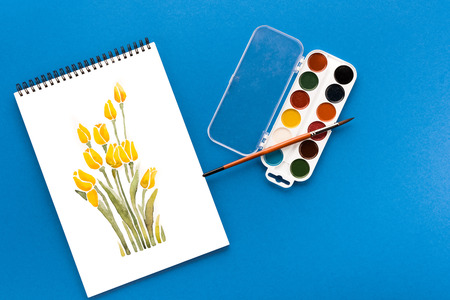 drawing of flowers, paints and brush on blue, springtime conceptの写真素材