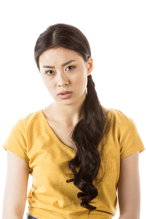 attractive young asian girl looking at camera isolated on whiteの写真素材