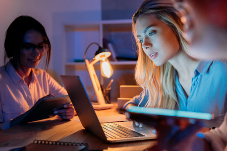 businesswomen working with digital devices while sitting at home officeの写真素材
