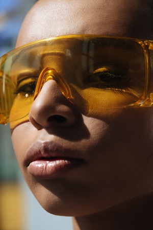 african american sensual woman sunbathing in protective orange goggles and looking at camera