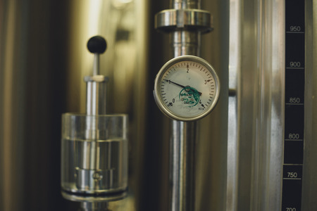 Close-up view of modern brewery equipment with gaugeの写真素材