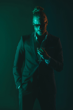 stylish man in tuxedo holding glass with cocktailの写真素材