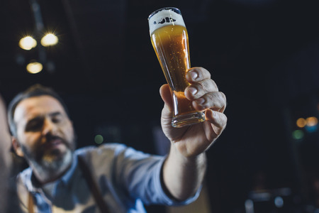 Brewery worker with glass of beer