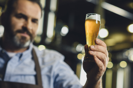 Brewery worker with glass of beer