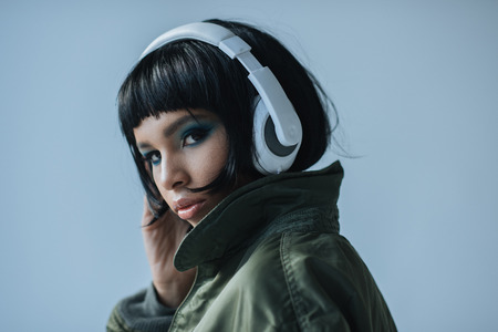 confident woman in headphones looking at cameraの写真素材