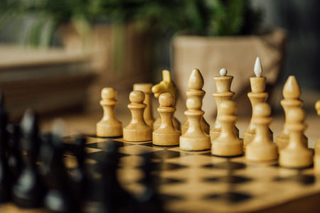 Old chess board set for a new game on the table. Selective focus