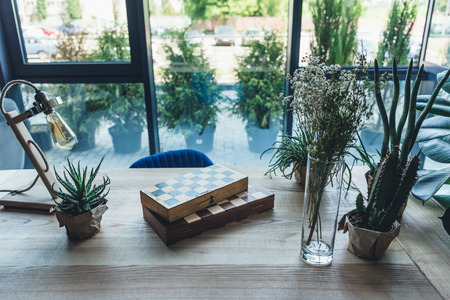 Studio workplace with chess boards, artistic work tools and green plants