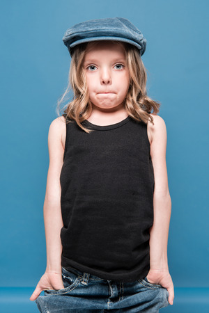 stylish little girl looking at camera with hands in pocketsの写真素材