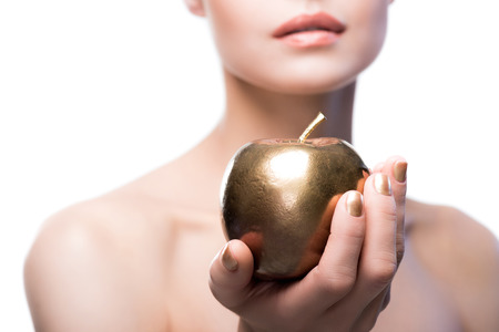 young lady holding golden apple isolated on whiteの写真素材