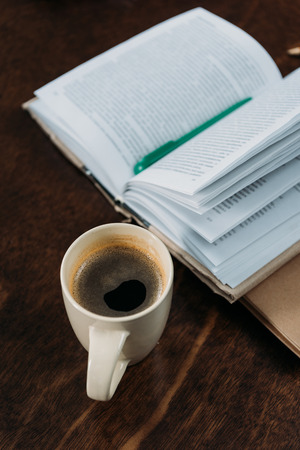 coffee cup with book and pen on wooden tabletopの写真素材
