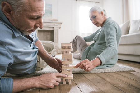couple playing wood blocks game at homeの写真素材
