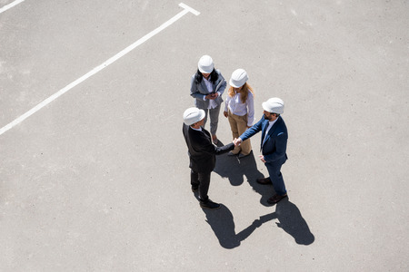 group of architects in formal wear talking at meeting outdoors
