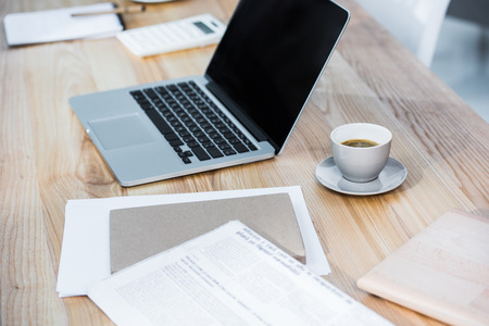 Modern office workplace with coffee and laptop computerの写真素材