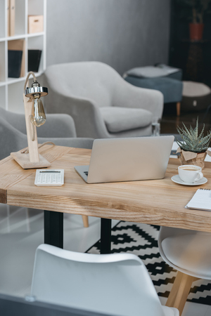 Modern office workplace with coffee and laptop computerの写真素材