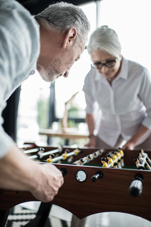 business colleagues playing foosball at officeの写真素材