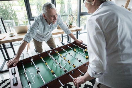 business colleagues playing foosball at office