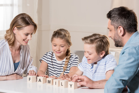 family sitting at table, word family by wooden brickの写真素材