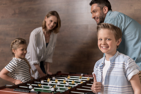 smiling family playing foosball together