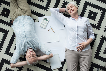 Senior business colleagues lying on floorの写真素材