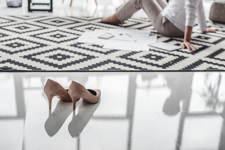 Stilettos and senior businesswoman working with documents on floorの写真素材
