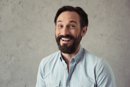 handsome bearded man smiling and looking at cameraの写真素材