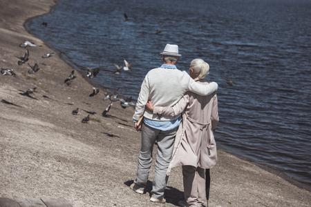 senior couple walking on river shore at daytimeの写真素材