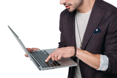 stylish man typing on laptop isolated on white