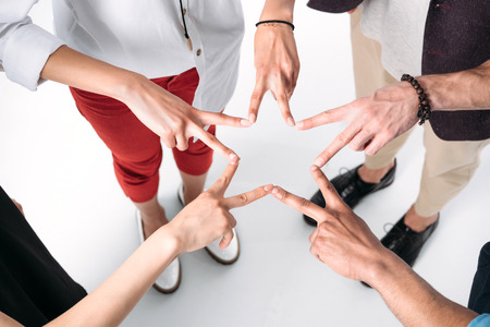 young friends gathered hands in form of star