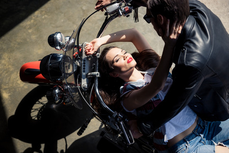 stylish young couple in love spending time together on motorcycleの写真素材