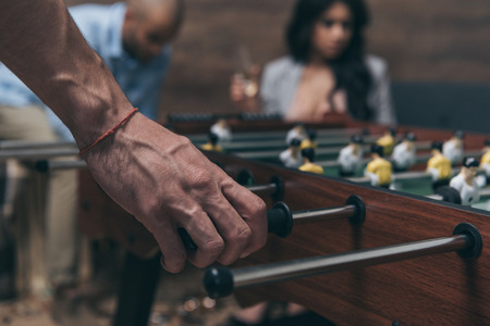 young people playing foosball indoorsの写真素材
