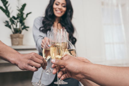 friends clinking with champagne glasses at home partyの写真素材