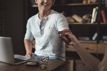 man paying with credit card in coffee shopの写真素材