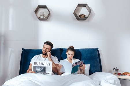 young loving couple reading in bedの写真素材