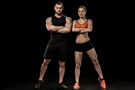 sportive man and woman posing together and looking at cameraの写真素材