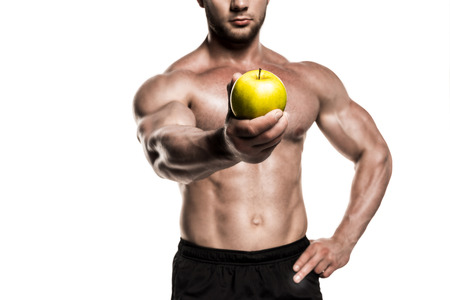 cropped view of shirtless muscular sportsman presenting apple isolated on whiteの写真素材