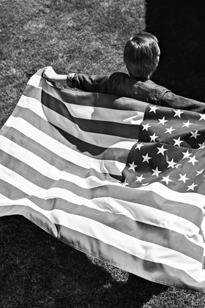 little boy running with american flagの写真素材