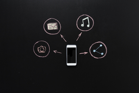 social networking icons drawn around of smartphone with black screenの写真素材