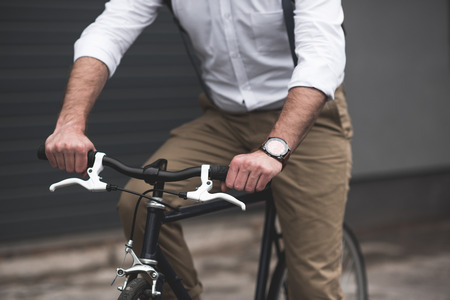 stylish young man riding bicycle