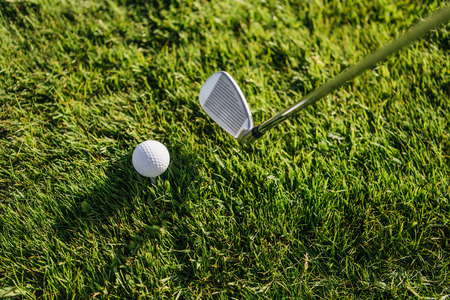 Close-up view of golf club and ball on green grassの写真素材